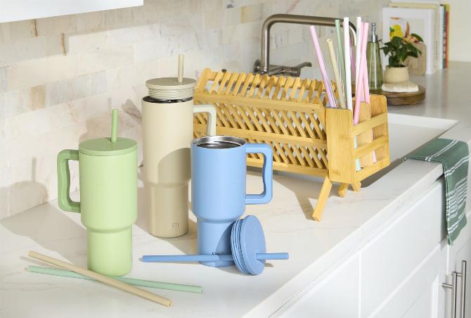 Многоразовые бутылки для воды и соломинки на кухонном столе